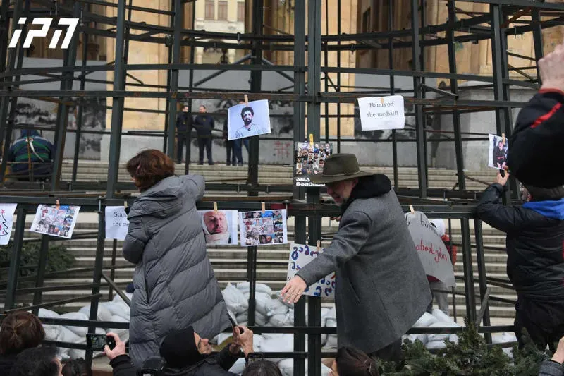 Media representatives have hung photos of people injured and beaten during protests on a Christmas tree being installed in front of the parliament