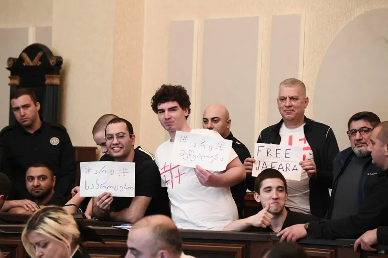 საპროტესტო აქციების დროს ჯგუფური ძალადობის ორგანიზების და მასში მონაწილეობის ბრალდებით დაკავებულებს სასამართლოზე მიტანილი აქვთ ფურცლები წარწერებით: „FREE JAFARA“, „არც შეწყალება“, „არც საპროცესო“