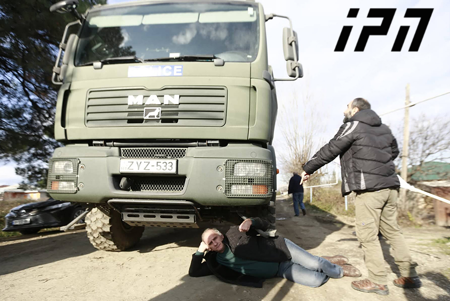 Opposition members lay down on road blocked with trucks