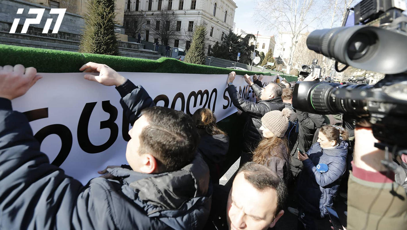 ოპოზიციის ლიდერებმა აქციის მონაწილეებთან ერთად პარლამენტის წინ ბანერი წარწერით "სირცხვილი“ გააკრეს