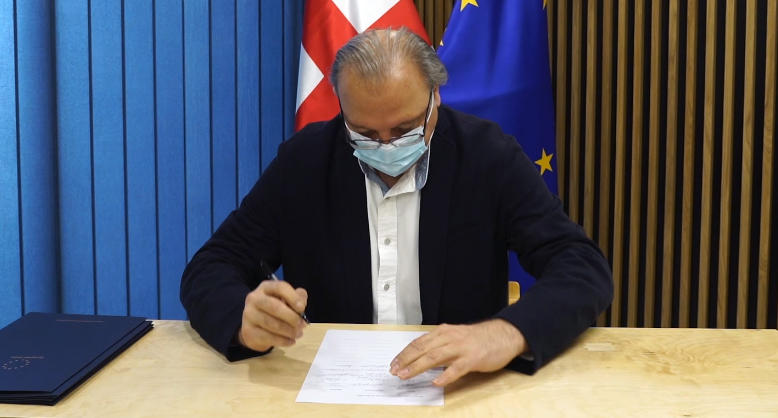 გრიგოლ ვაშაძე შეთანხმების დოკუმენტს ხელს აწერს