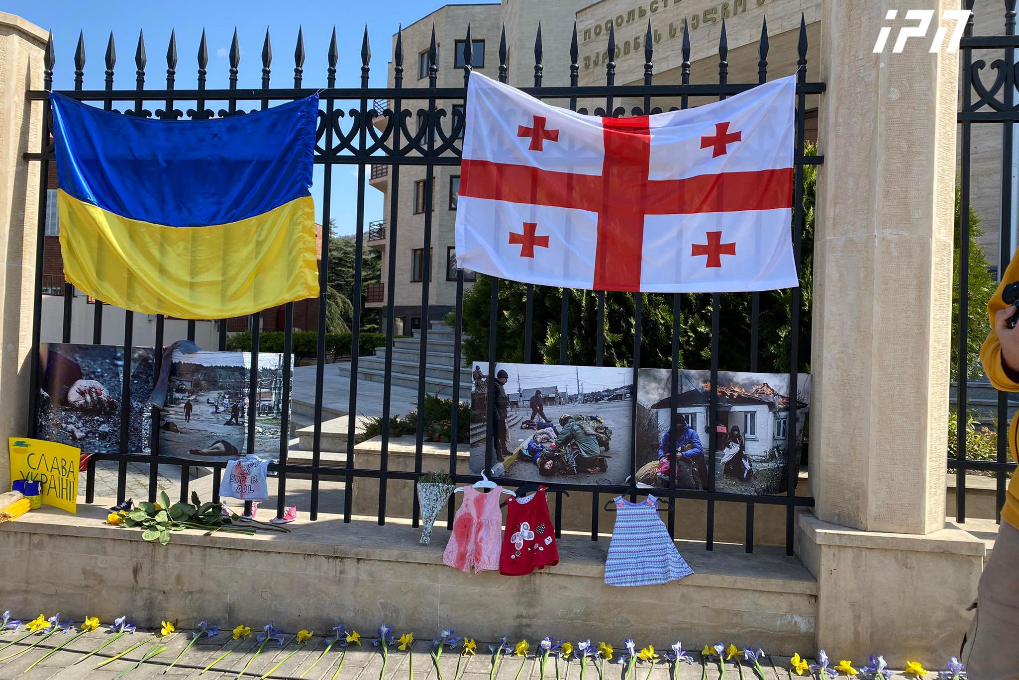 თბილისში, უკრაინის საელჩოსთან რუსეთის აგრესიის შედეგად დაღუპულთა ფოტოსურათები, ბავშვების ტანსაცმელი და ყვავილები მიიტანეს