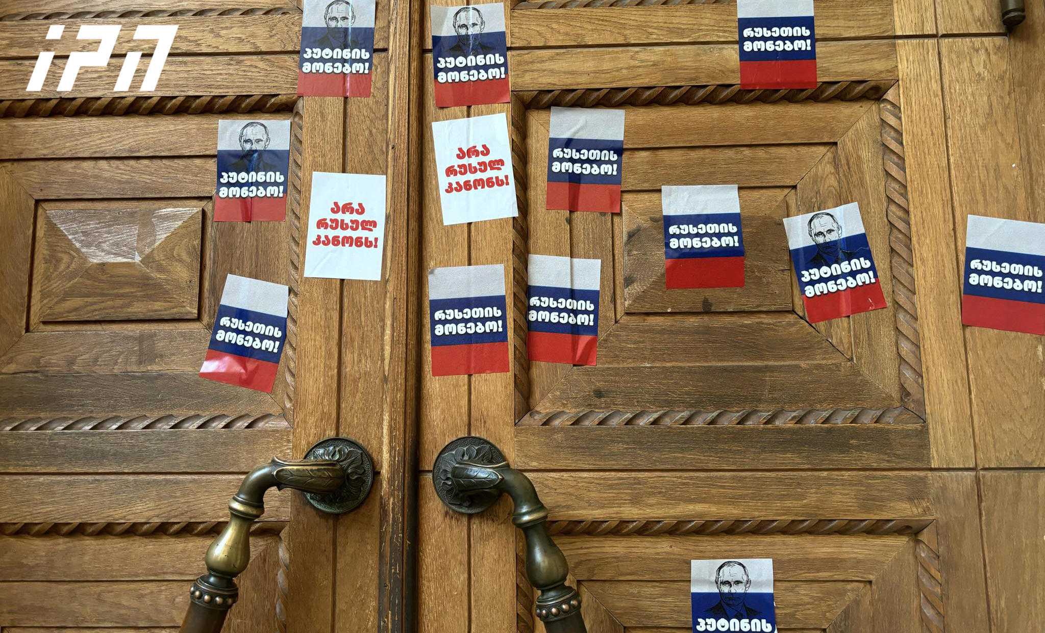 აქციის მონაწილეებმა პარლამენტის შესასვლელზე სტიკერები - „არა რუსულ კანონს“, „პუტინის მონებო!“ გააკრეს