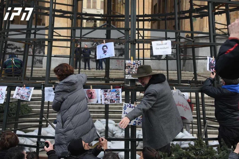 Media representatives have hung photos of people injured and beaten during protests on a Christmas tree being installed in front of the parliament