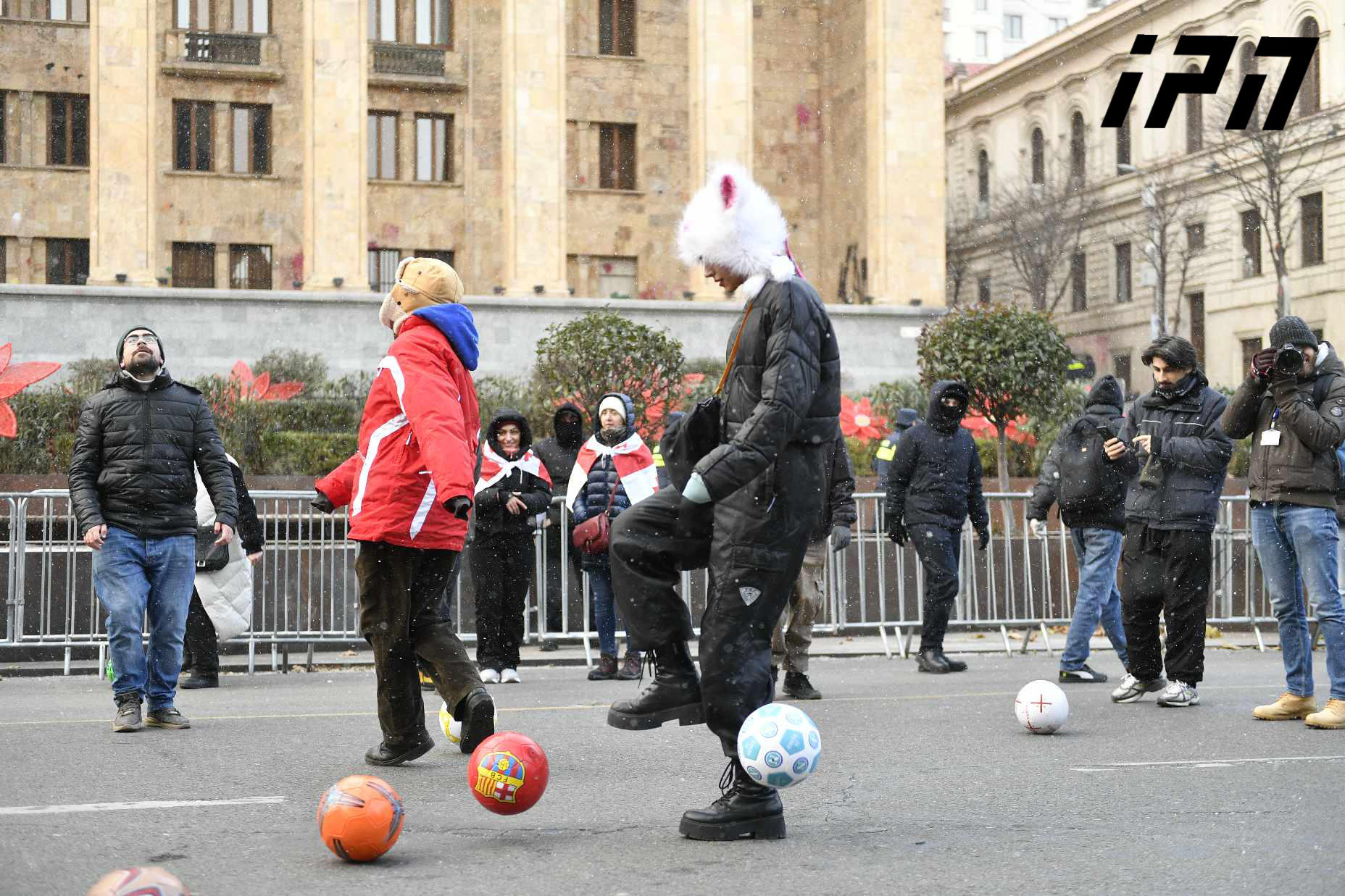 The participants of the rally are playing ball near the parliament